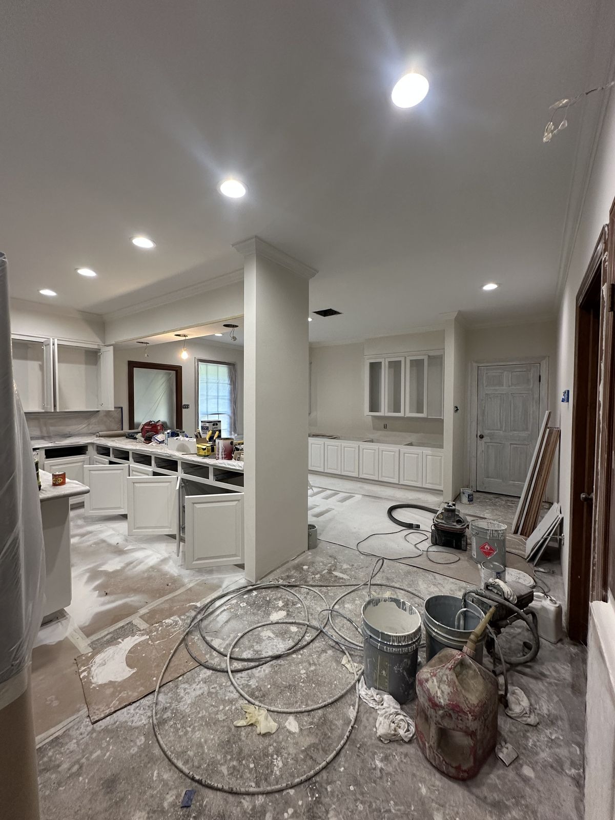 Cozinha e sala em acabamento, com iluminação embutida, ferramentas e equipamento de obra
