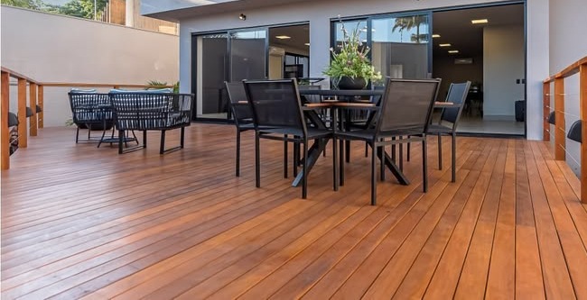 Exterior da mesma moradia depois da construção de um deck em madeira com zona de refeições